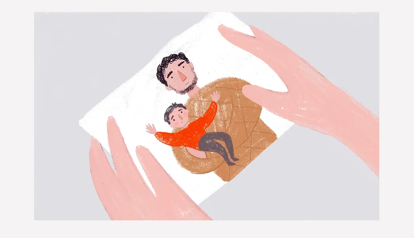 Hands holding a photo of a father hugging his young son, an illustrated scene from the Nebesna Sotnia animated film